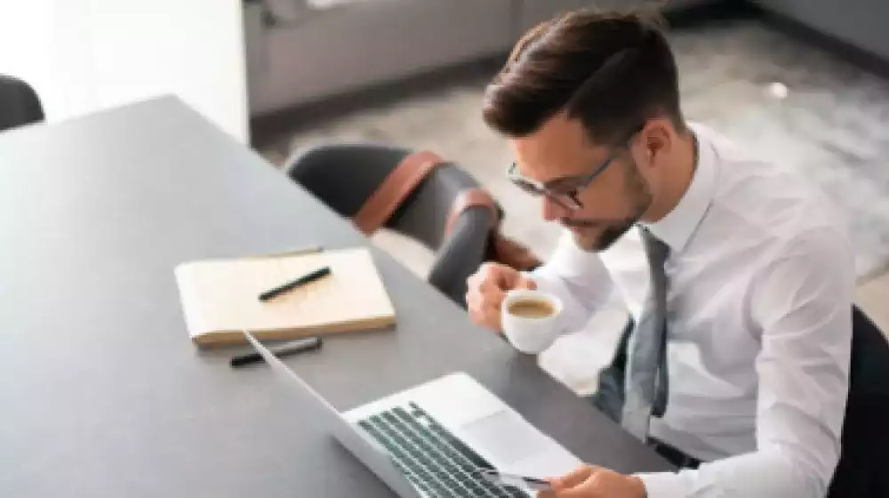 Hombre revisando pago de proveedores en computadora