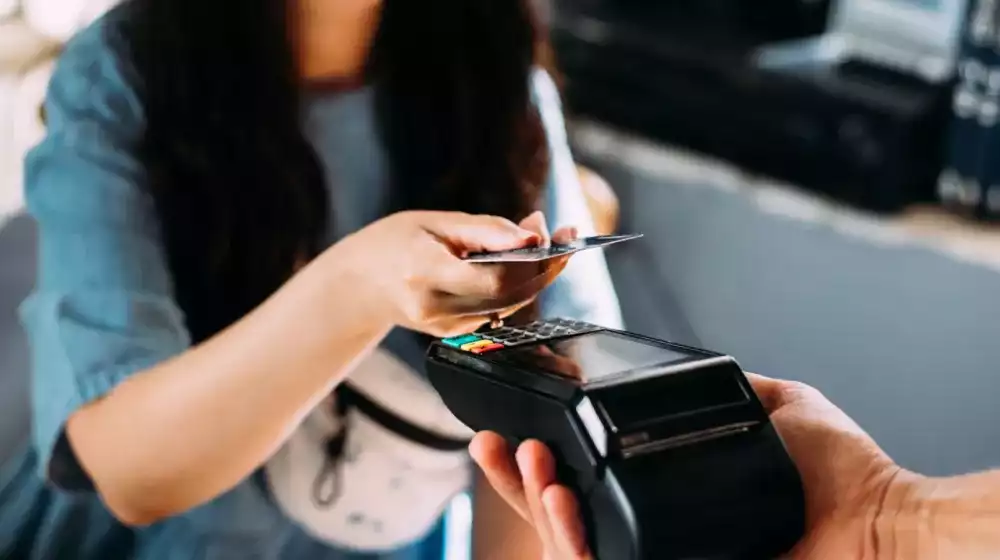 Mujer pagando en un datáfono con su tarjeta de crédito o débito