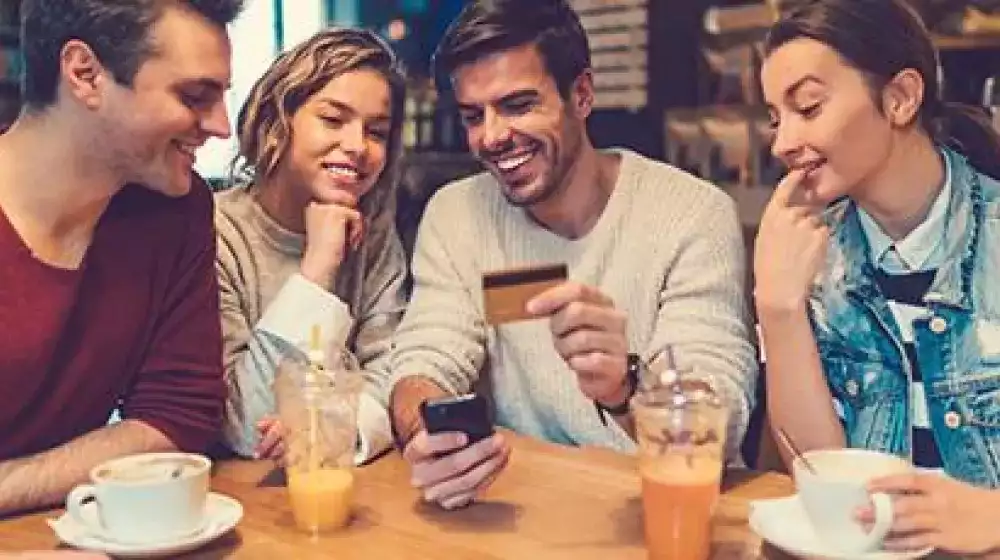 grupo de amigos viendo un telefono con cara de asombro