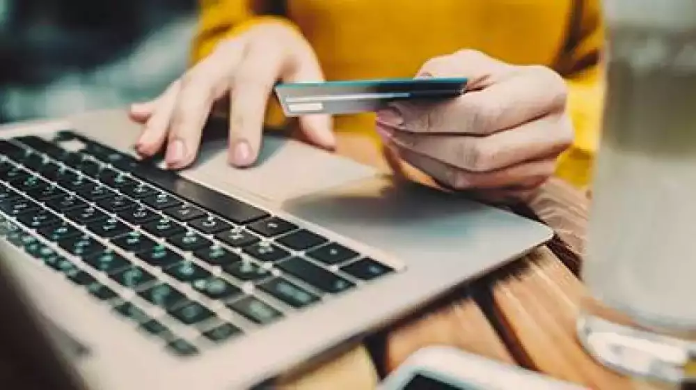 Persona con su tarjeta y un computador 