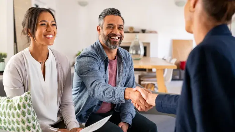 Pareja de empresarios hace una inversión y cierra el trato con un apretón de manos